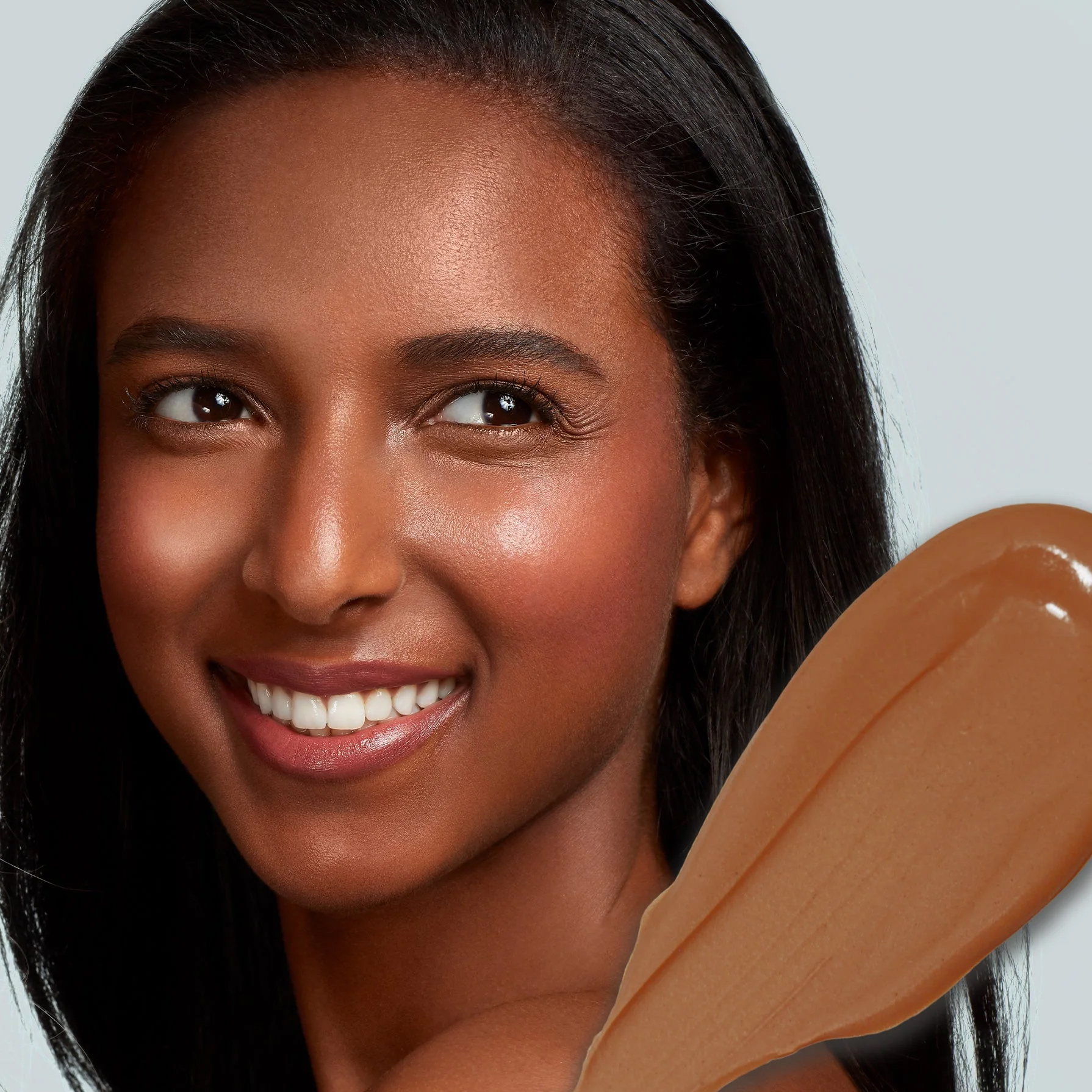 A close up of a model with a swipe of product over the corner of the image.