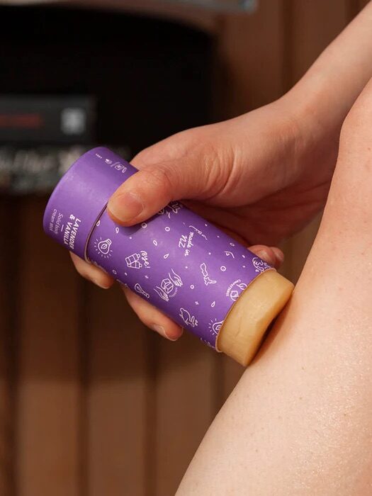 A close up of a model applying the Ethique Body Cream stick on their leg.