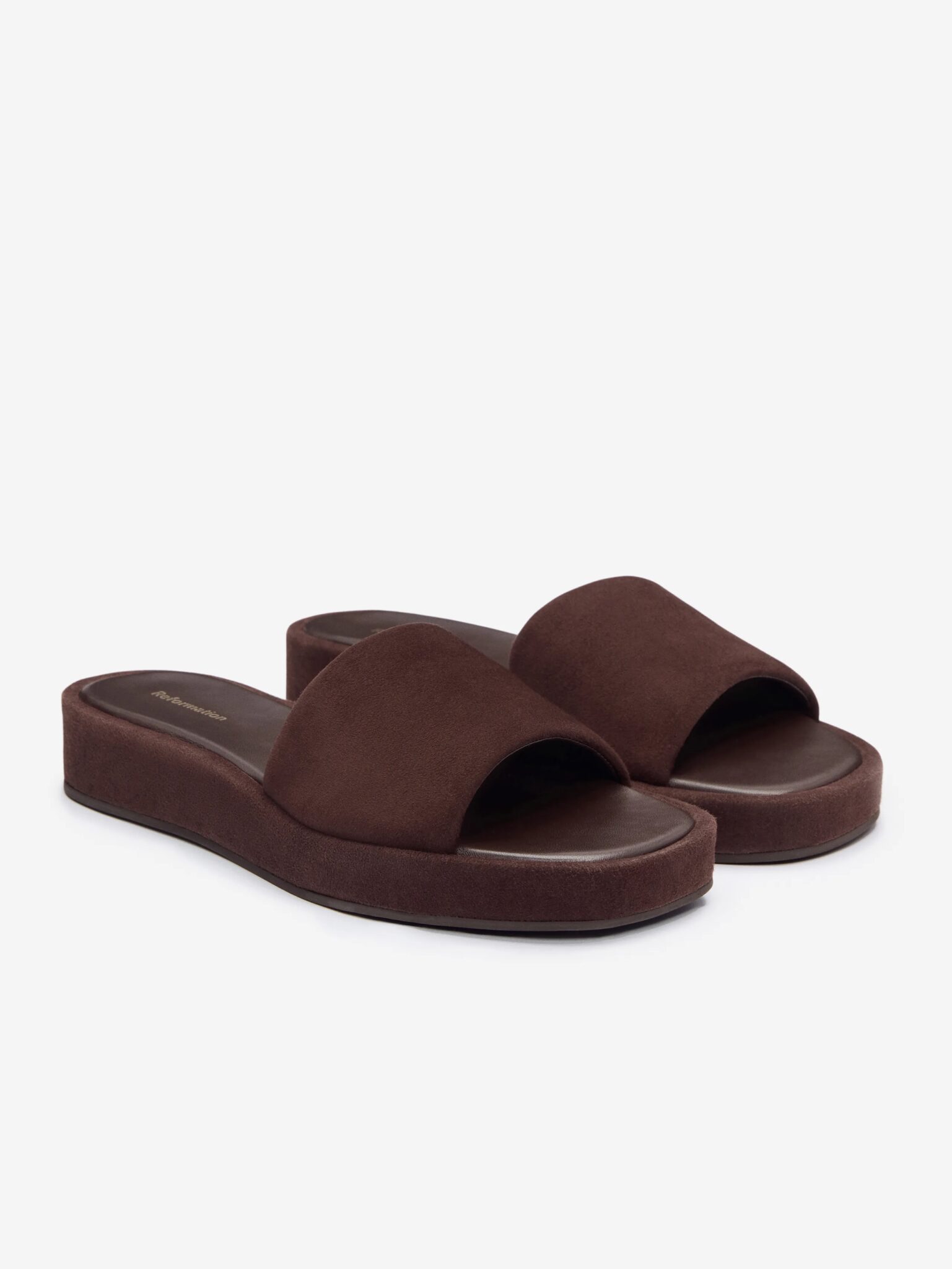 Pair of brown suede slide sandals with open toes and platform soles, displayed against a plain white background.