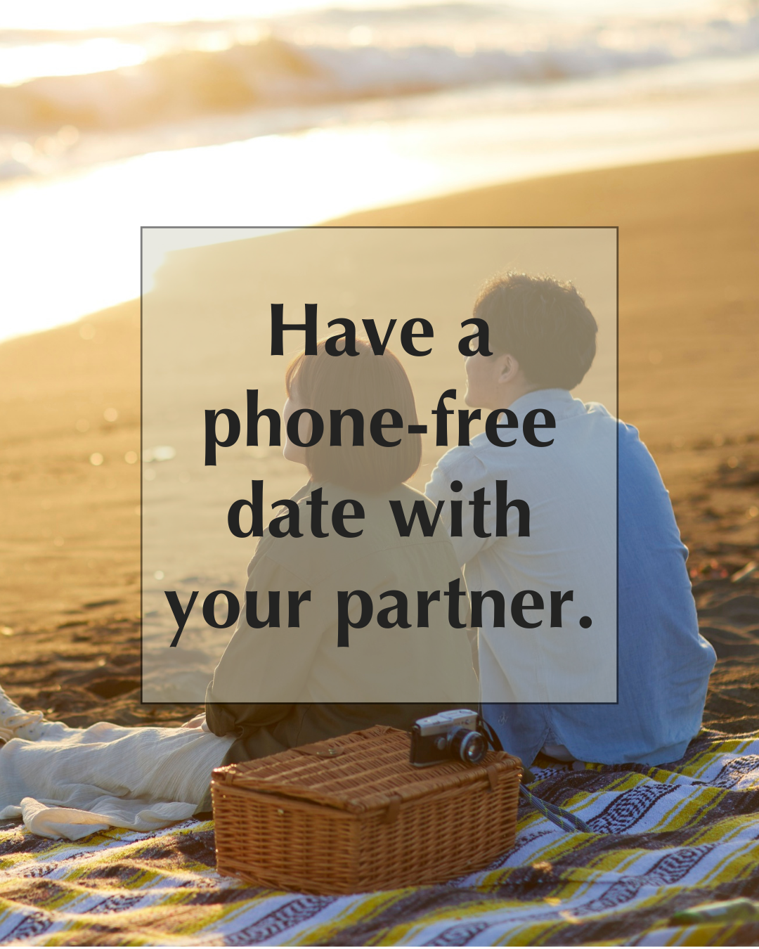 Two people sit together on a picnic blanket at the beach near sunset, with a camera and basket, and text that reads, "Have a phone-free date with your partner.
