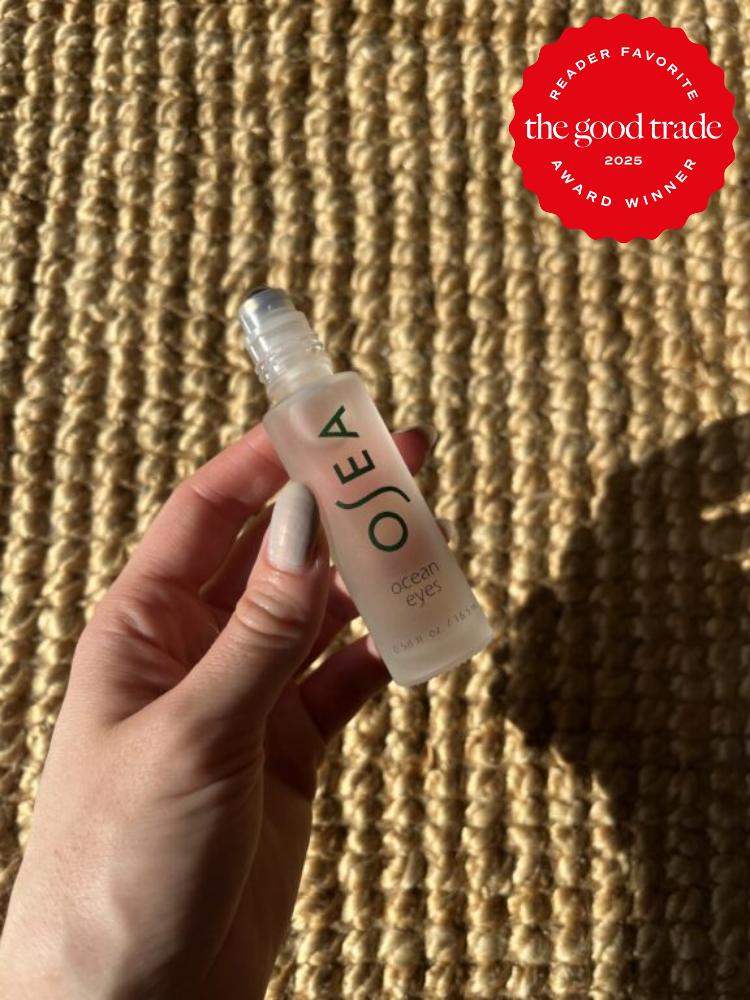 Closeup of a hand holding OSEA's Ocean Eye's serum. 