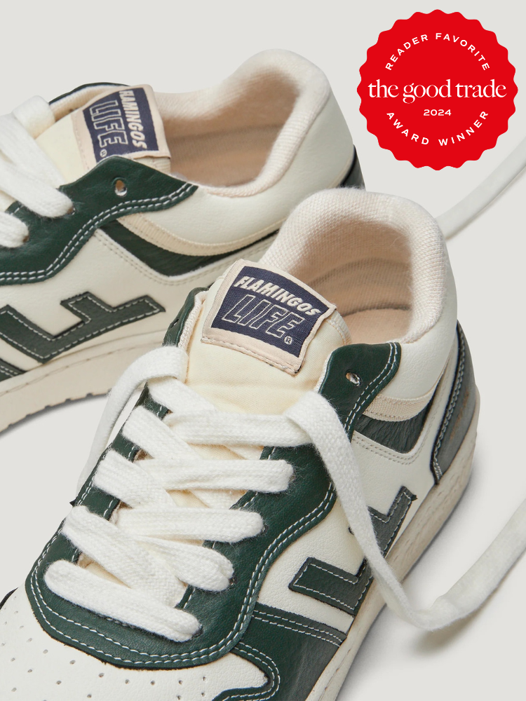 A pair of white and dark green Flamingos Life sustainable sneakers with white laces, alongside a red 2024 "The Good Trade" award badge.