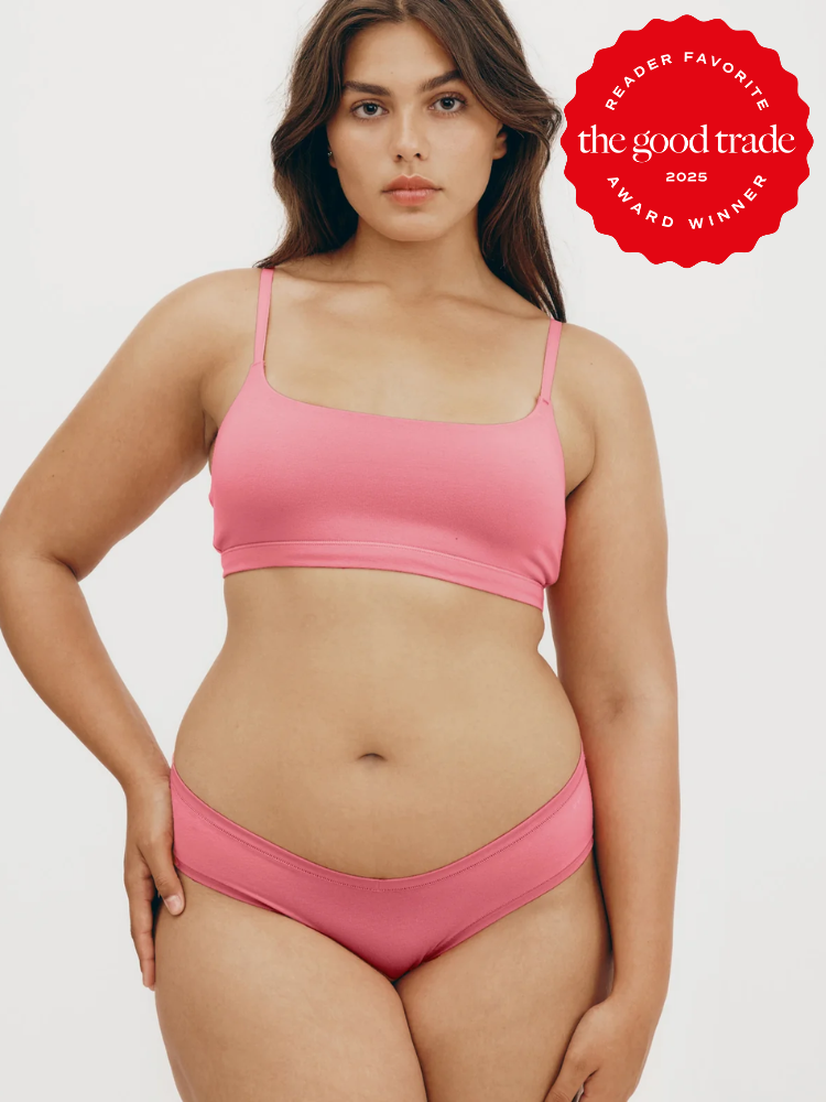 A person models pink underwear against a plain background. A red badge reads "Reader Favorite, the good trade, Award Winner 2025.